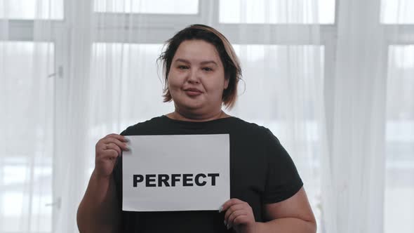 Concept Body Positivity a Chubby Smiling Woman Holds a Sign with the Inscription PERFECT Looking in