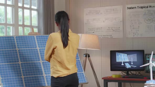 Woman Walks Into Looking At The Solar Cell That Has Model Small House With Solar Panel