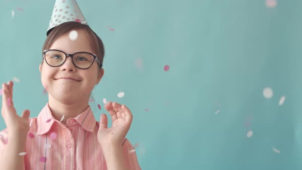 Girl with Down Syndrome Throwing Confetti in Air