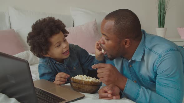 Joyful Father and Son Enjoying Leisure on Bed