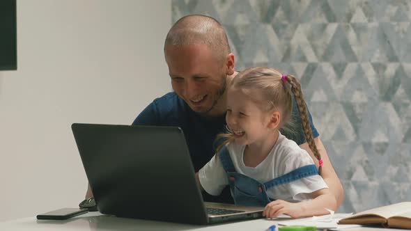 Happy Daddy and Daughter Have Fun Doing Homework on Laptop