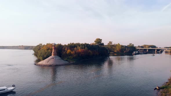 Amazing revealing drone footage of the old stone lighthouse by the Danube river. Beautiful autumn co