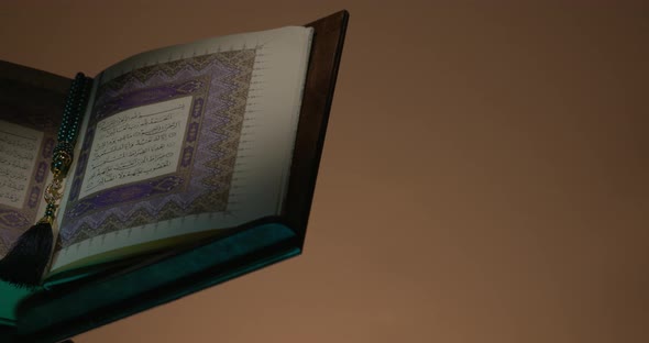 Holy Quran On Book Rest At Left Side With Prayer Beads Rotation