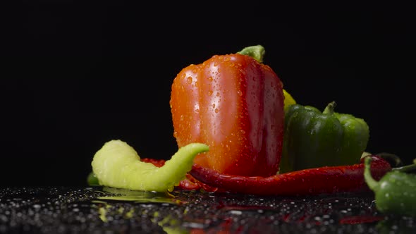 Peppers Wet with Drops of Moisture on Black Background