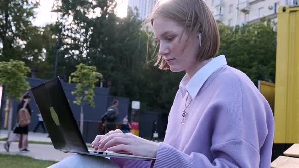 Concentrated Young Woman Freelancer in Wireless Headphones