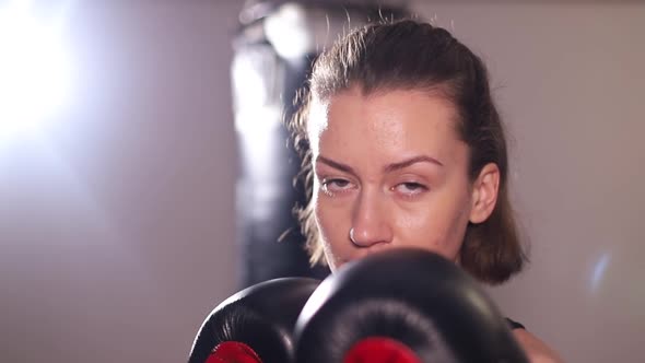 Aggressive Female Boxer Practices Punches in Training
