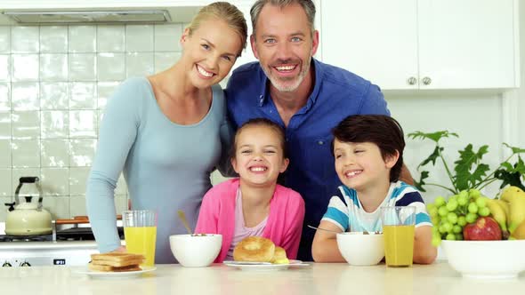 Portrait of smiling family standing in kitchen