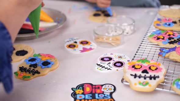 Step by step. Mother and daughter decorating sugar skull cookies with royal icing for Dia de los Mue