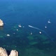 Drone shot of kayaks and boats passing in the ocean, people exploring caves and tunnels. - VideoHive Item for Sale