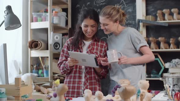 Artsy Women in Workshop Looking at Tablet