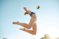 Dynamic bottom view image of young sportive woman playing beach volleyball, hitting ball in a jump  - PhotoDune Item for Sale