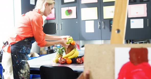 Teacher arranging food for painting on table