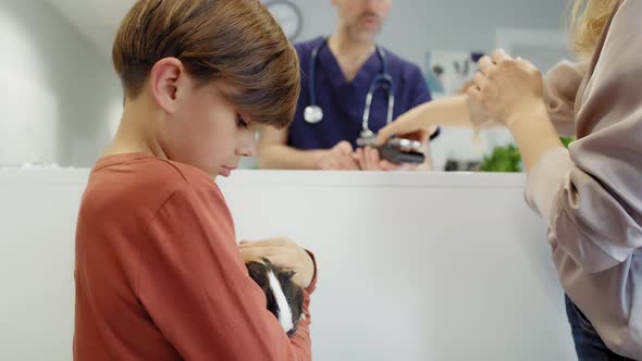 Woman with child paying for helping their guinea pig. Shot with RED helium camera in 4K.