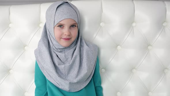Portrait of Muslim Teen Girl in Grey Hijab is Looking in Camera