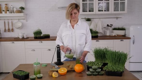 A Vegetarian Woman Pours a Fruit and Vegetable Smoothie Into a Jar with a Straw