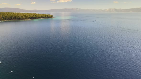 Drone flying up and towards the shores of Sugar pine state park with intermitted cloud cover.