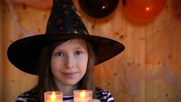 Portrait of Adorable Teen Girl Wearing Halloween Hat Holding Candles and Smiling