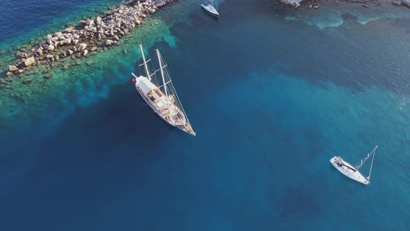 Sailing yachts anchored in the bay with clear and turquoise water