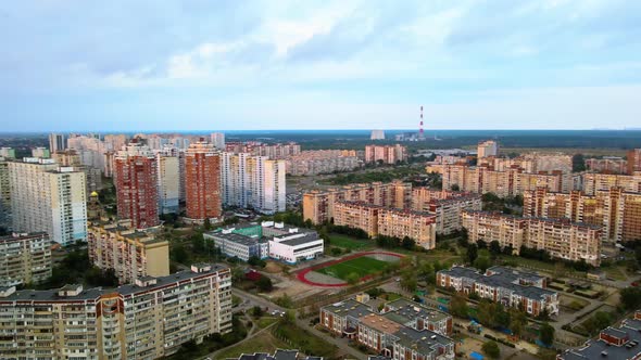 Aerial view overlooking the Secondary school a sports and football field, in middle of apartment bui