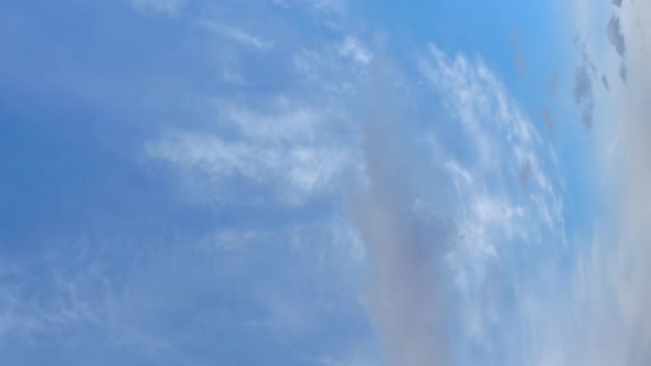 Vertical format: Cumulus and cirrus clouds time-lapse on blue sky day