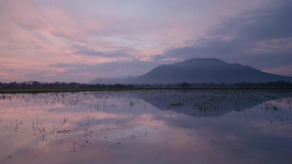 Sunrise reflection Bukit Mertajam Hill in water.