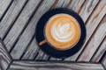 Top view on stylish latte coffee mug with flower art on wooden table background - PhotoDune Item for Sale