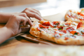 Child hand taking slice of fresh delicious pepperoni pizza served on craft paper - PhotoDune Item for Sale