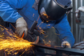 During the metalwork workplace in which a master grinds metal with a grinder, sparks are visible - PhotoDune Item for Sale