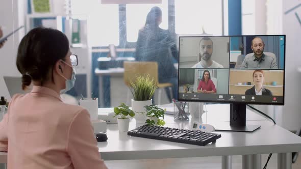 Executive Businesswoman with Medical Face Mask Having Online Videocall Meeting