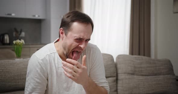 Adult Man Expressing Disgust on Sofa