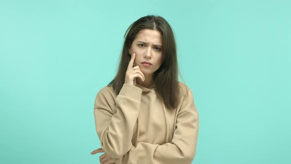 Pensive Young Woman in Hoodie Touching Head and Looking Intense While Thinking Then Pitch an Idea