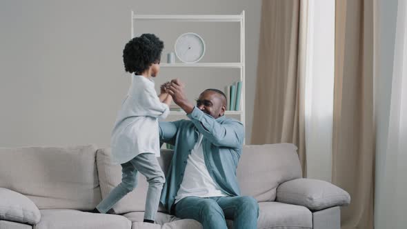 African American Father with Little Daughter Spend Their Free Time Together Having Fun Playing