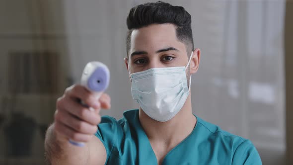 Arabian Male Medical Worker Doctor Surgeon Man in Protective Mask Taking Temperature with Noncontact