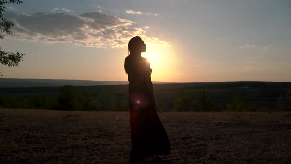 Young Woman in Long Dress Enjoying Nature on the Sunset