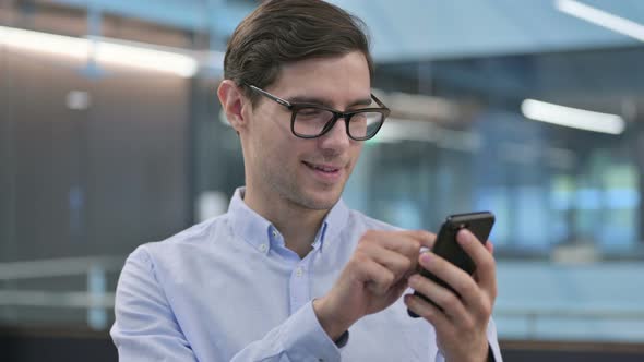 Portrait of Young Man Celebrating on Smartphone