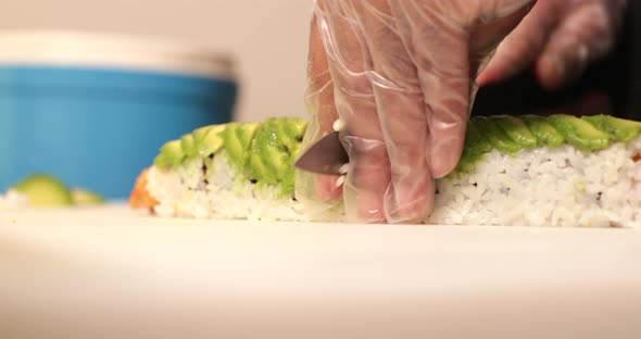 Slicing A Delicious And Healthy Sushi Rolls With Ripe Avocado And Fried Shrimps. - close up shot