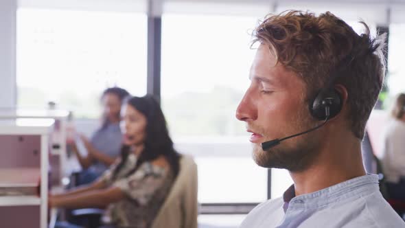 Professional businessman talking on phone headset in modern office in slow motion