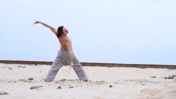 Caucasian Man with Long Hair Practicing Qigong Outdoors