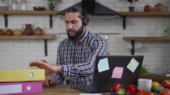 Serious Busy Handsome Man Typing on Laptop Keyboard Checking Documents in Folder