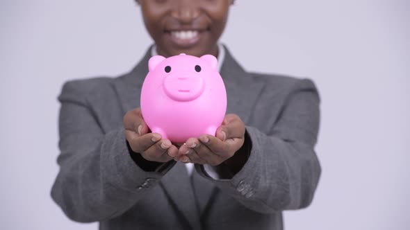 Young Happy African Businesswoman Giving Piggy Bank