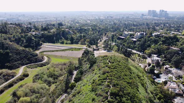 Aerial drone forward moving shot of roads and private mansions along hillside in Beverly Hills, Cali