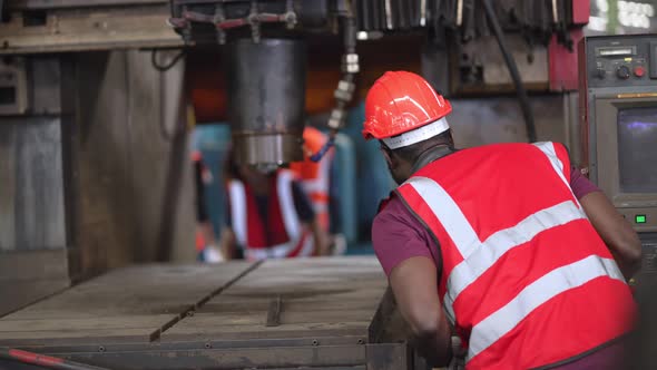 Group of heavy industrial worker checking and repairing big machine in the factory