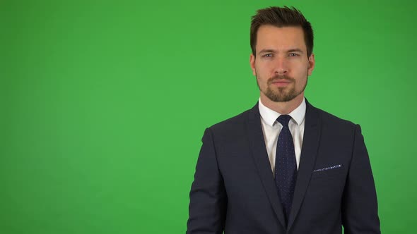 A Young Handsome Businessman Looks Seriously at the Camera - Green Screen Studio