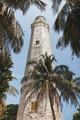 White lighthouse in Dondra, Sri Lanka. Point Dondra. Palm trees and a blue sky. - PhotoDune Item for Sale