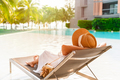 Young woman traveler relaxing and enjoying the beach view by a tropical resort pool while traveling - PhotoDune Item for Sale