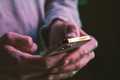 Man using mobile phone typing text or checking social media in neon lights. - PhotoDune Item for Sale