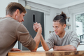 Father competing in arm wrestling with teen son, family spending time together - PhotoDune Item for Sale