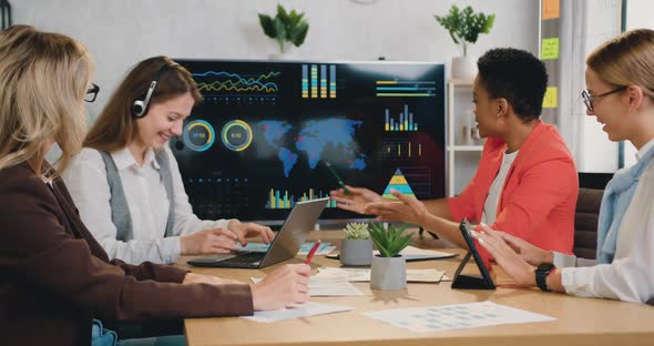 Woman Presenting Financial Graphing Data while Showing to Presentation Working