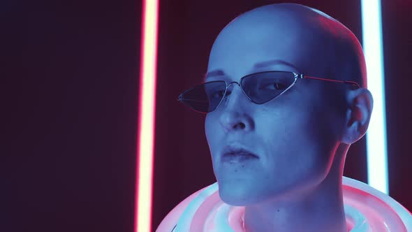 Bald Woman in Trendy Glasses Posing in Studio with Neon Light