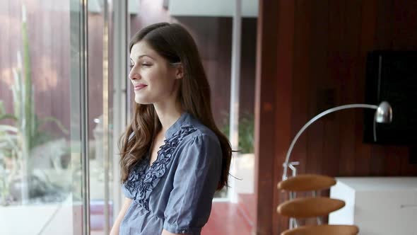 Happy young woman looking through window